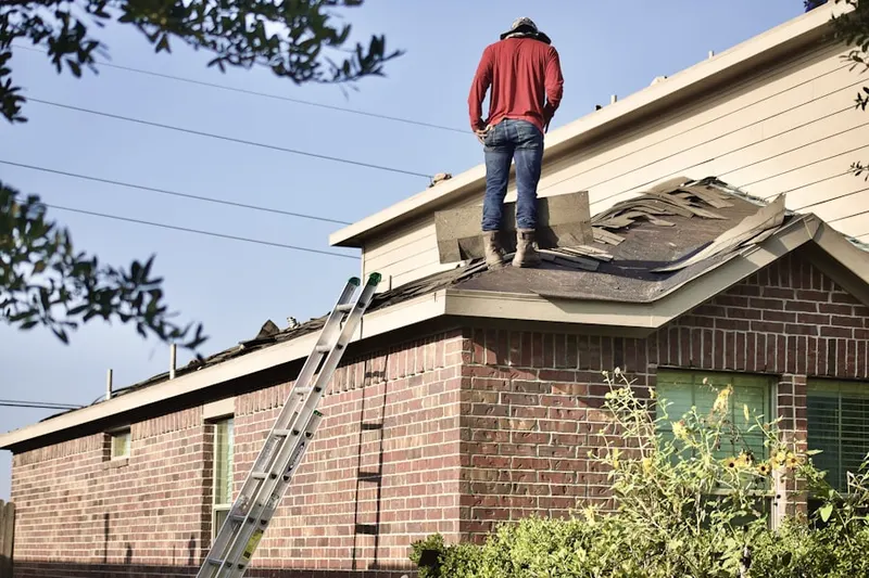 Professional roofer working on a residential roof in Lowell